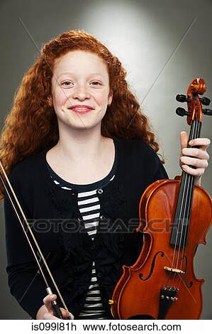 Stock Image - Portrait of mixed race teenage girl holding violin. Fotosearch