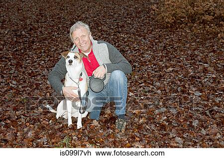 Portrait of senior man with dog in forest View Large Photo Image Stock Image - Portrait of senior man with dog in forest. Fotosearch