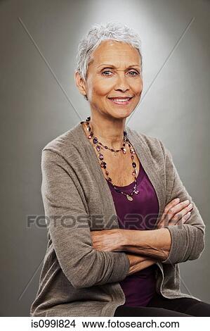 Portrait of senior woman smiling, studio shot View Large Photo Image Picture - Portrait of senior woman smiling, studio shot. Fotosearch