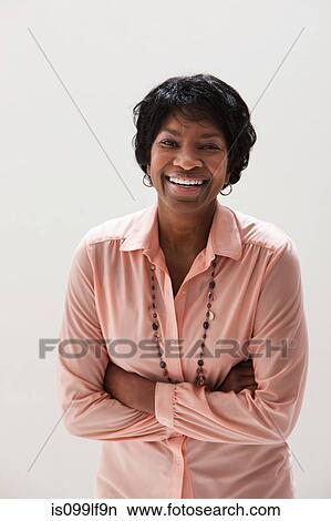 Picture - Portrait of smiling African American mature woman, studio shot. Fotosearch