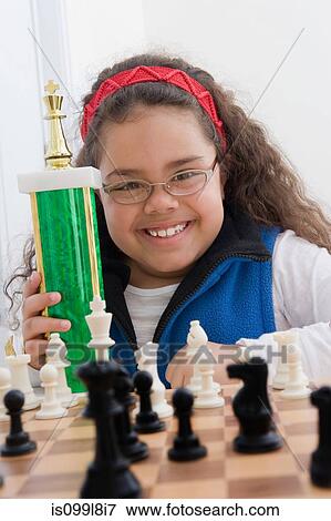 Portrait of young girl holding chess trophy View Large Photo Image Stock Photo - Portrait of young girl holding chess trophy. Fotosearch