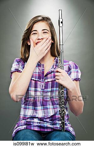 Portrait of young teenage girl laughing and holding flute View Large Photo Image Stock Photo - Portrait of young teenage girl laughing and holding flute. Fotosearch