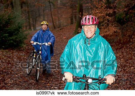 Stock Image - Senior couple cycling in forest. Fotosearch