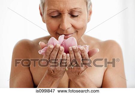 Stock Photo - Senior woman holding flower. Fotosearch