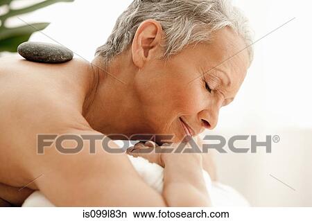 Senior woman receiving stone therapy View Large Photo Image Picture - Senior woman receiving stone therapy. Fotosearch