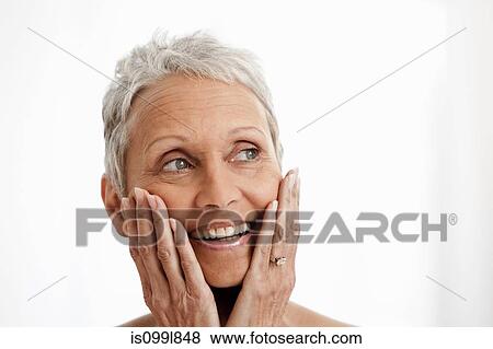 Stock Photo - Senior woman smiling against white background. Fotosearch