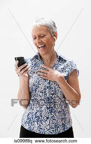 Stock Photography - Senior woman using cellphone, studio shot. Fotosearch