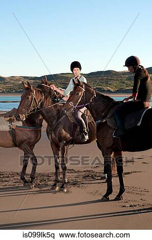 Two women riding horses on beach View Large Photo Image Stock Photography - Two women riding horses on beach. Fotosearch
