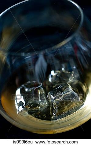 Whiskey on the rocks in a tumbler View Large Photo Image Stock Photograph - Whiskey on the rocks in a tumbler. Fotosearch