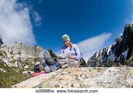 Stock Photo - Woman reading map at camp, Picket Pass, North Cascades National Park, Washington State, USA. Fotosearch