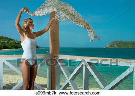 Woman shaking sarong in breeze by the ocean View Large Photo Image Stock Image - Woman shaking sarong in breeze by the ocean. Fotosearch