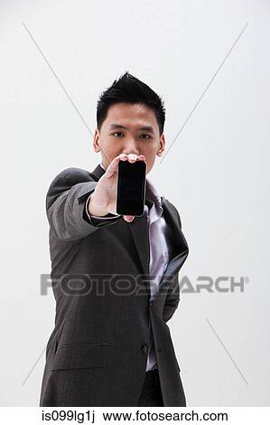 Young Asian businessman holding cellphone, studio shot View Large Photo Image Stock Image - Young Asian businessman holding cellphone, studio shot. Fotosearch