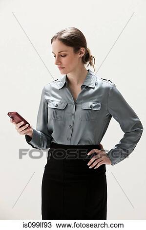 Young businesswoman using cellphone, studio shot View Large Photo Image Stock Image - Young businesswoman using cellphone, studio shot. Fotosearch