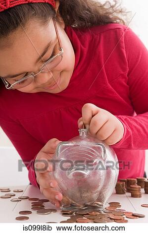Young girl inserting coins in piggy bank View Large Photo Image Stock Image - Young girl inserting coins in piggy bank. Fotosearch