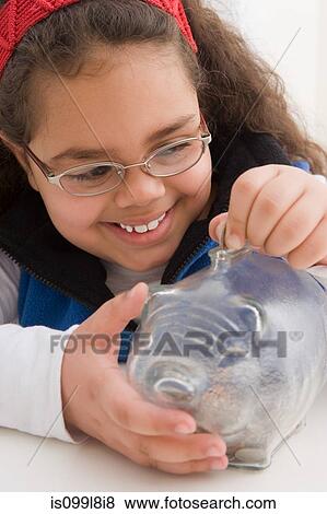 Young girl inserting coins in piggy bank View Large Photo Image Stock Photo - Young girl inserting coins in piggy bank. Fotosearch