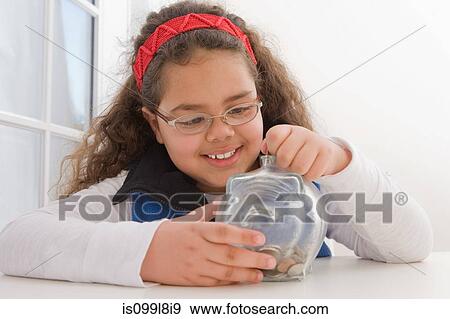Young girl inserting coins in piggy bank View Large Photo Image Stock Photo - Young girl inserting coins in piggy bank. Fotosearch