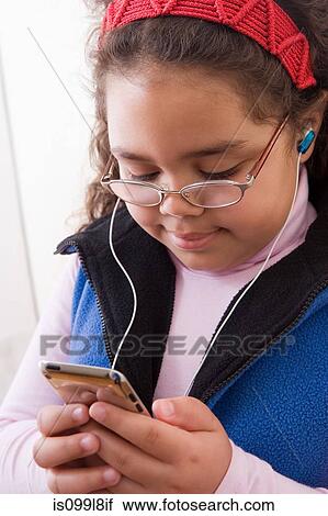 Stock Image - Young girl listening to music. Fotosearch