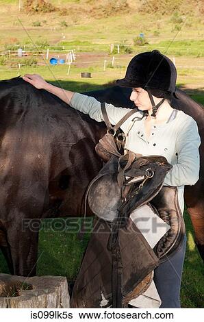 Young woman patting horses back View Large Photo Image Stock Photograph - Young woman patting horses back. Fotosearch