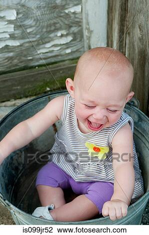 Baby sitting in a bucket and laughing View Large Photo Image Stock Image - Baby sitting in a bucket and laughing. Fotosearch