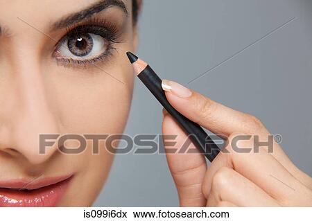 Beautiful woman applying eyeliner View Large Photo Image Stock Photo - Beautiful woman applying eyeliner. Fotosearch