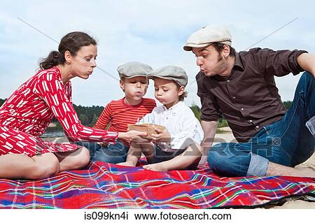 Boy and family with birthday cake on picnic blanket View Large Photo Image Stock Image - Boy and family with birthday cake on picnic blanket. Fotosearch