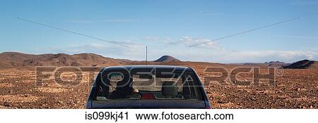 Stock Image - Car in stony desert, Morocco, North Africa. Fotosearch