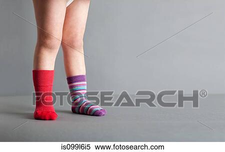 Child wearing one red sock and one striped sock View Large Photo Image Stock Photography - Child wearing one red sock and one striped sock. Fotosearch