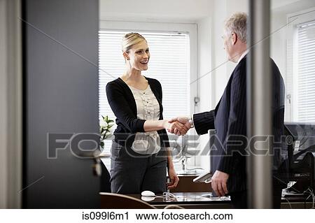 Colleagues shaking hands in office View Large Photo Image Stock Image - Colleagues shaking hands in office. Fotosearch