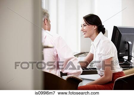 Stock Photo - Colleagues talking in office. Fotosearch