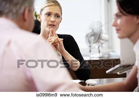 Colleagues talking in office View Large Photo Image Stock Photo - Colleagues talking in office. Fotosearch