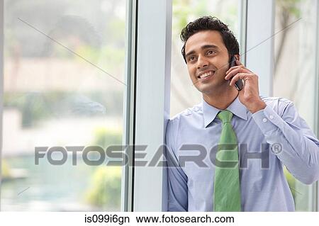 Executive talking on a mobile phone View Large Photo Image Picture - Executive talking on a mobile phone. Fotosearch
