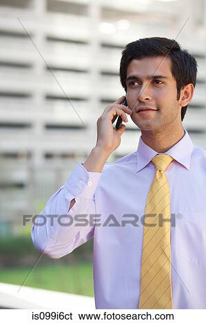 Executive talking on a mobile phone View Large Photo Image Stock Photograph - Executive talking on a mobile phone. Fotosearch