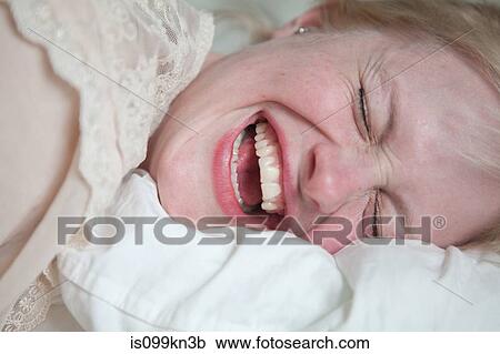 Stock Image - Face of young woman laughing. Fotosearch