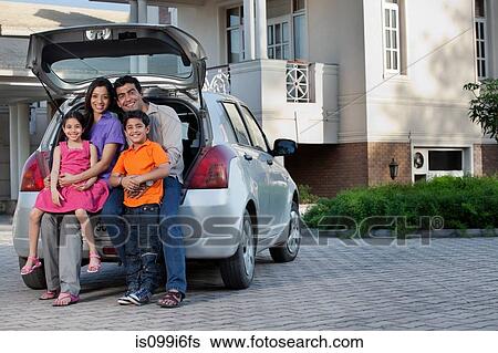 Stock Photograph - Family sitting at the back of a car. Fotosearch