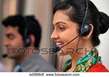Stock Image - Female call center agent smiling. Fotosearch