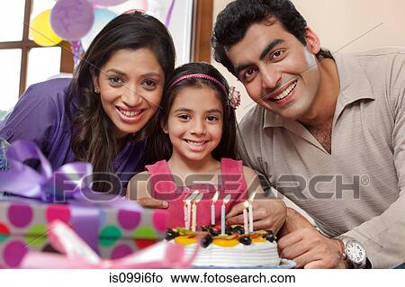Girl celebrating her birthday with parents View Large Photo Image Picture - Girl celebrating her birthday with parents. Fotosearch