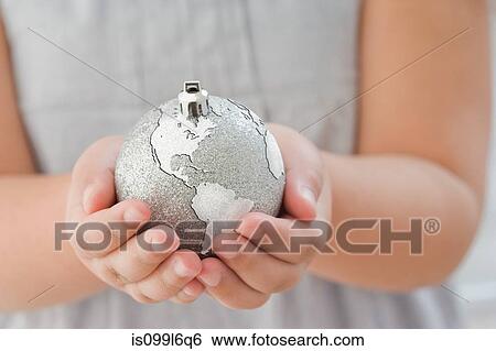 Stock Photograph - Girl holding a globe decoration. Fotosearch