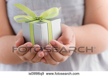 Stock Photo - Girl holding a small gift. Fotosearch