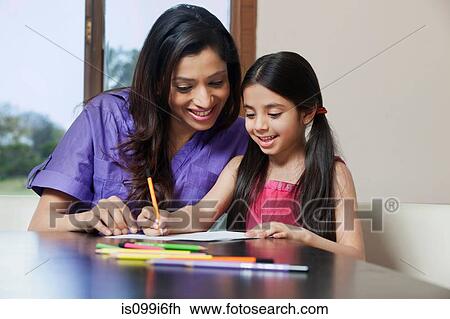Girl writing while her mother looks on View Large Photo Image Stock Image - Girl writing while her mother looks on. Fotosearch