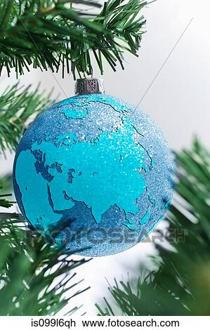 Stock Image - Globe bauble on christmas tree. Fotosearch
