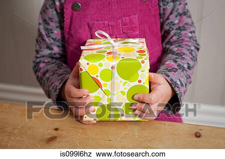 Stock Photo - Little girl holding a gift. Fotosearch
