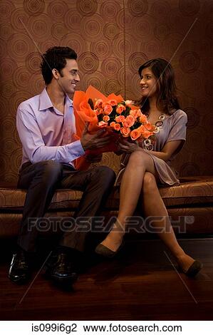 Stock Image - Man giving bouquet of flowers to a woman. Fotosearch