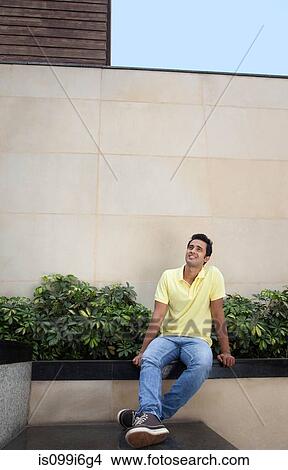 Picture - Man sitting outside. Fotosearch