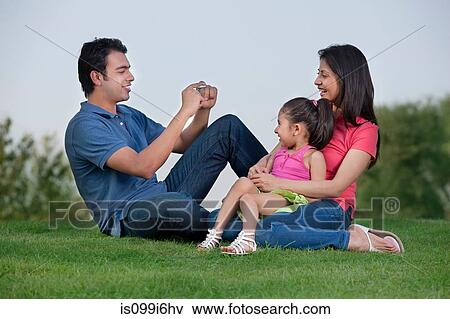 Man taking a photograph of his family View Large Photo Image Stock Photo - Man taking a photograph of his family. Fotosearch