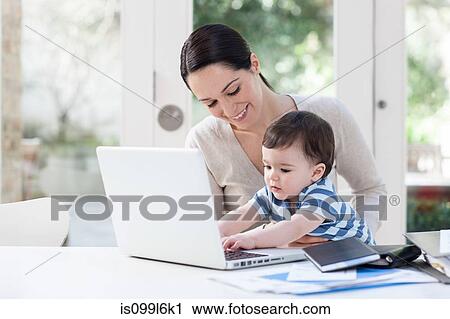 Stock Image - Mother and baby boy using laptop. Fotosearch
