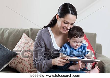 Mother and baby looking at digital tablet View Large Photo Image Stock Image - Mother and baby looking at digital tablet. Fotosearch