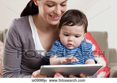 Stock Photo - Mother and baby looking at digital tablet. Fotosearch