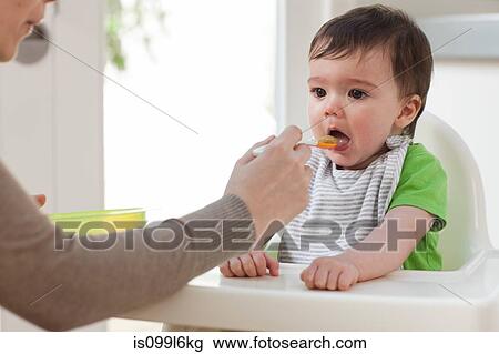 Mother feeding baby son View Large Photo Image Stock Image - Mother feeding baby son. Fotosearch