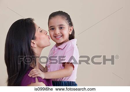 Stock Image - Mother kissing her daughter. Fotosearch