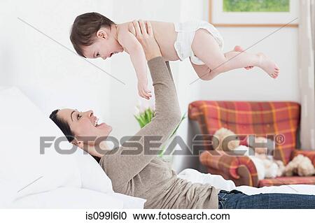 Mother lifting up baby boy View Large Photo Image Stock Image - Mother lifting up baby boy. Fotosearch